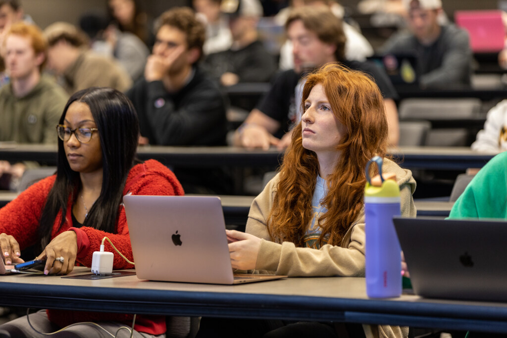 Students listen and take notes as professor give a lecture to the classroom