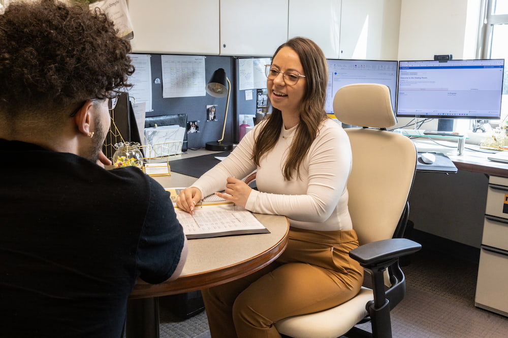 Student sits with advisor configuring the upcoming semester schedule