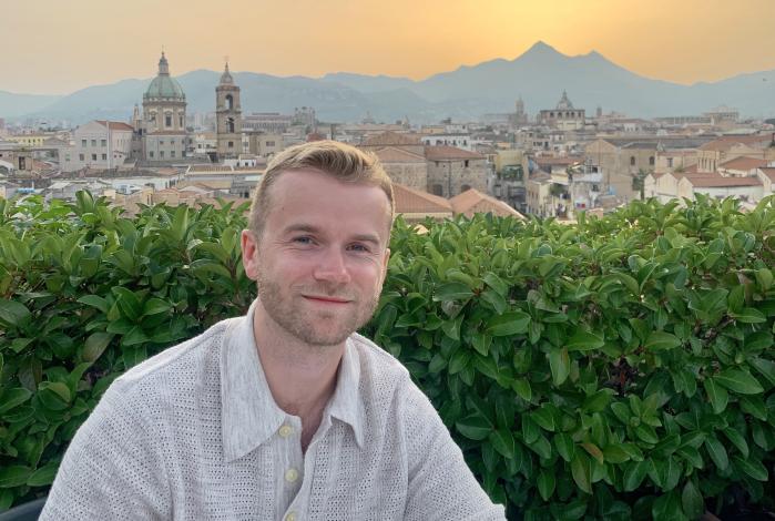 Image: Aaron Welker sitting in front of a sunset