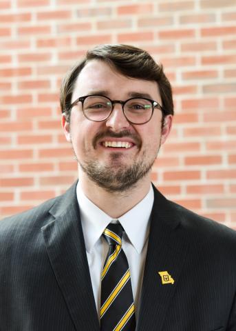 Image: Joseph Miller headshot in front of brick wall