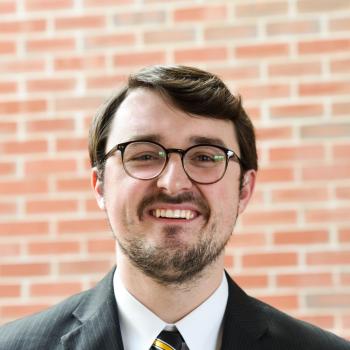 Image: Joseph Miller headshot in front of brick wall