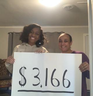 Alaina Meekins-Kent holds up a sign with Melissa Williams